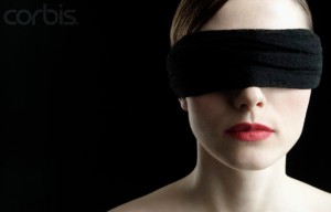 Woman wearing blindfold --- Image by © Bernd Vogel/Corbis